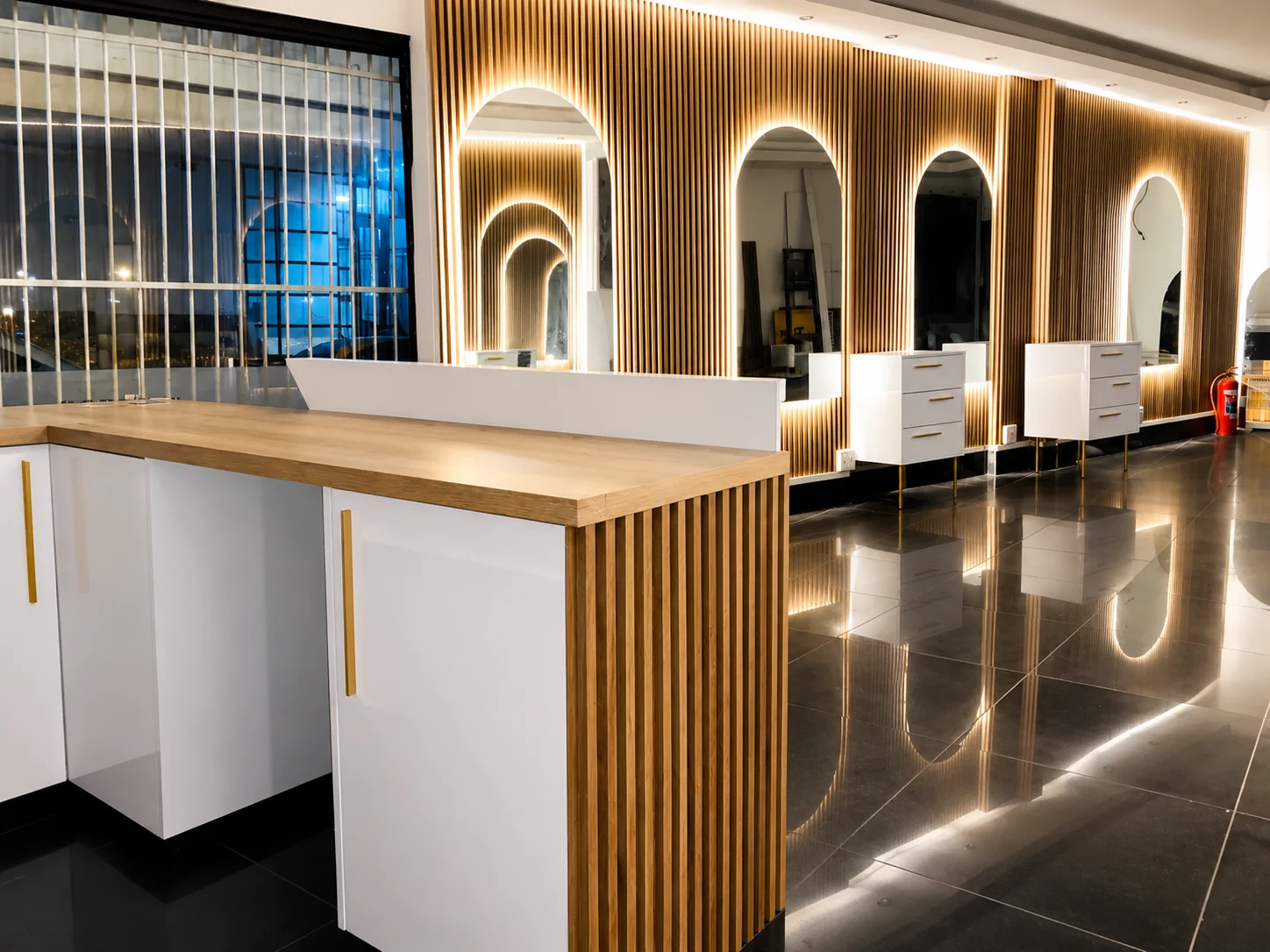 Reception and arched entryway of The Exclusive Hair Studio — warm ambient lighting, timber slats and brass accents